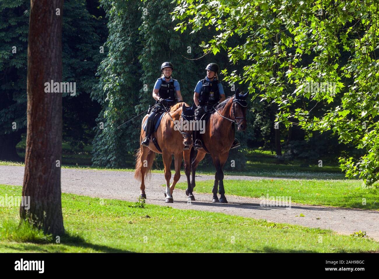 German woman Germany policewoman mounted police patrolling in the park Stock Photo