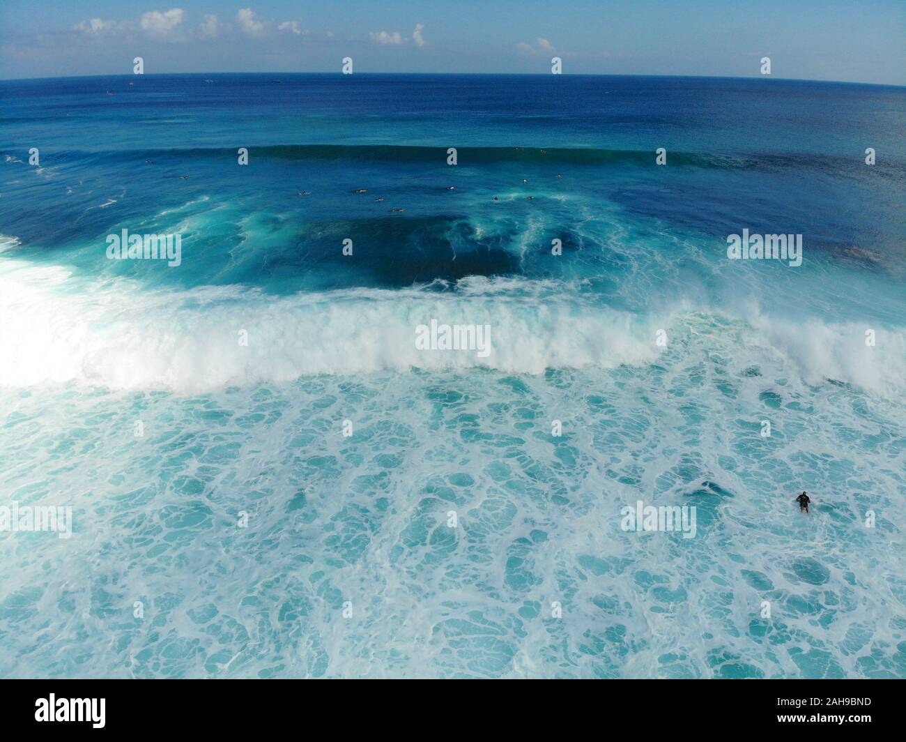 Aerial view of surfers on their board catching the waves,, big waves tropical blue ocean, Bali, Indonesia Stock Photo