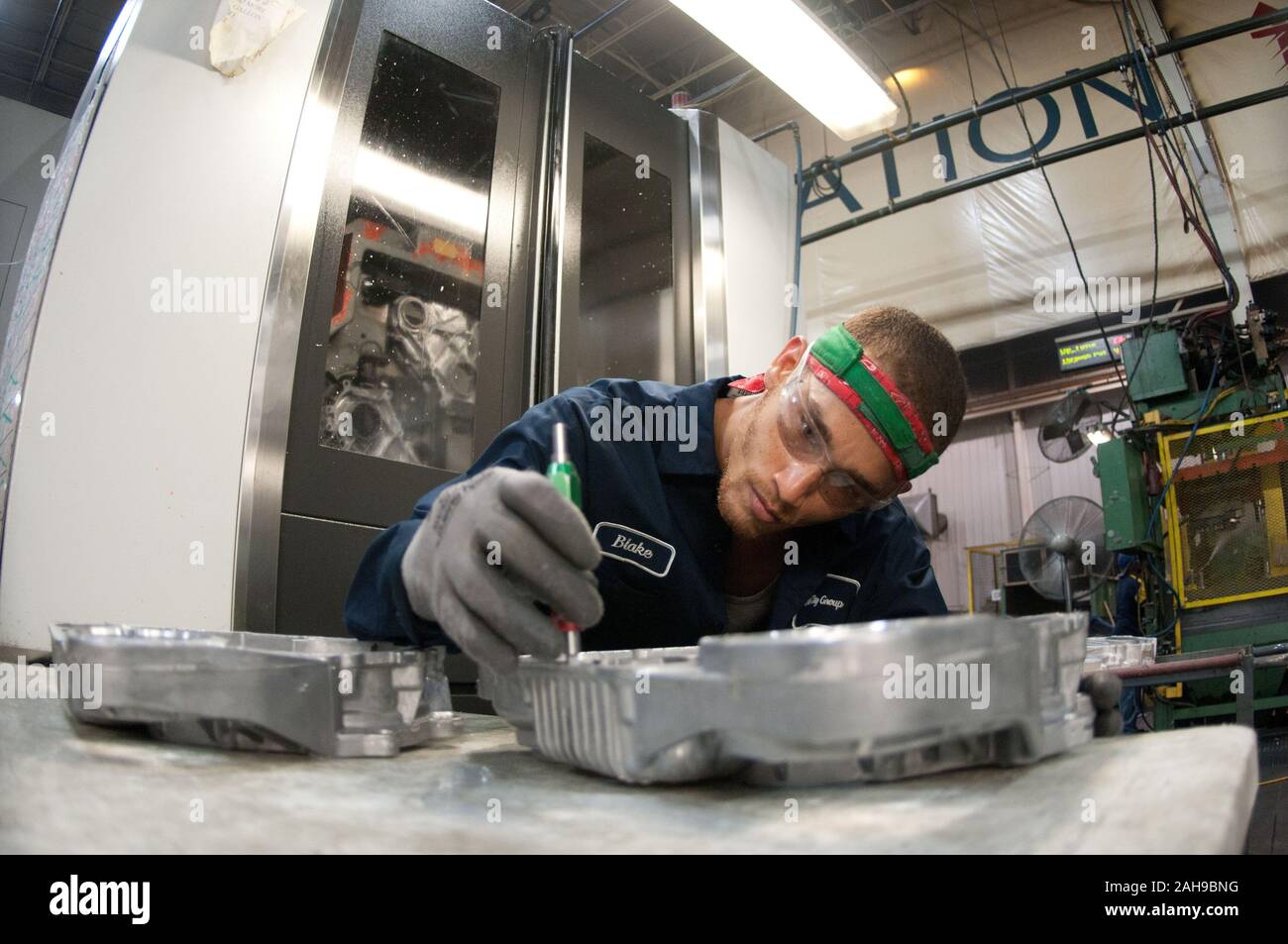 Computer Numerical Control (CNC) machine operator Blake Veeneman makes a process inspection after a casting is machined at Port City Group’s Port City Castings Corporation manufactures high-pressure aluminum die-castings, mostly for the automotive industry, in Muskegon, MI, facility on Wednesday July 20, 2011.  Port City Group boosted its employment by 12 percent over last year thanks to two Rural Business Guaranteed Loans totaling $9.6 million. In its 80,000 sq. ft. facility, machines that range from 800 – 1,600 tons, and cast A380 aluminum alloy products from melted ingots of aluminum, into Stock Photo
