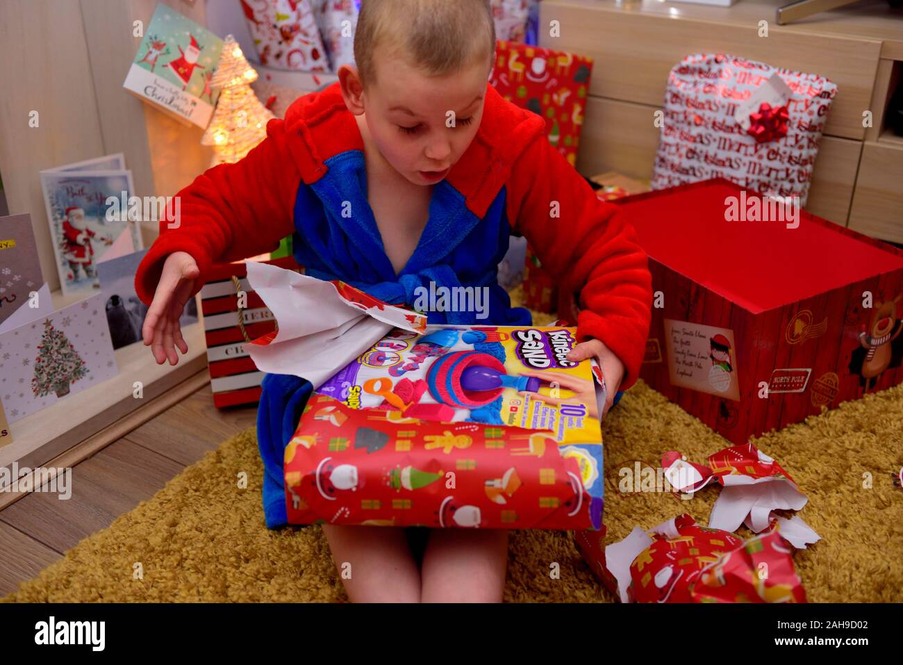 7 year old boy opening a christmas present Stock Photo