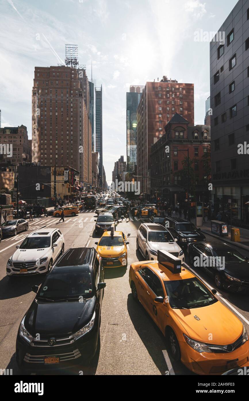 Busy street with cars and yellow taxis in Manhattan, in the large city