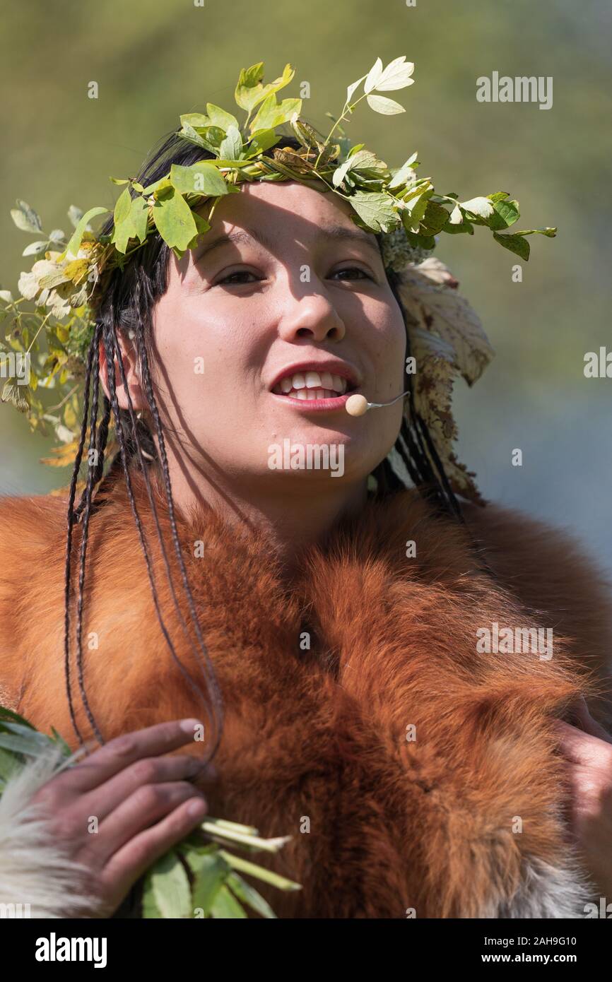 Expression young woman in clothing aborigine of Kamchatka Peninsula during Itelmens national ritual festival of thanksgiving nature Alhalalalay Stock Photo