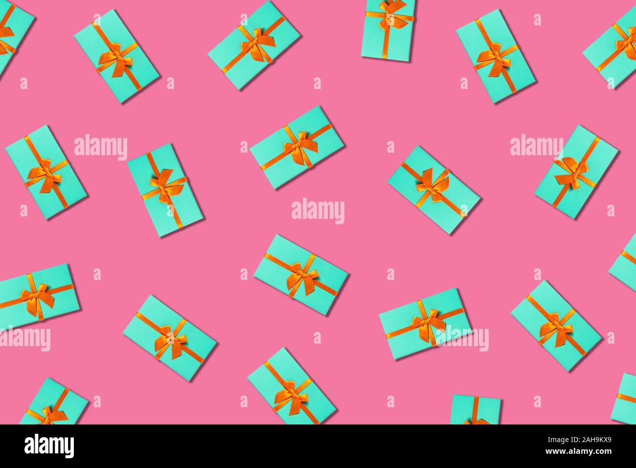 Orange bow on a mint boxes located on pink background. Stock Photo