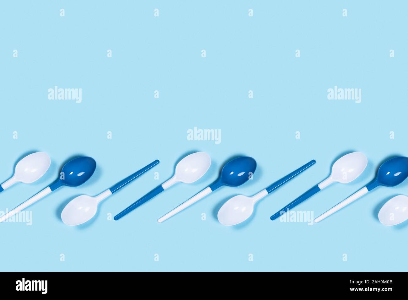 Dangerous plastic spoons. Environmental problem of plastic rubbish
