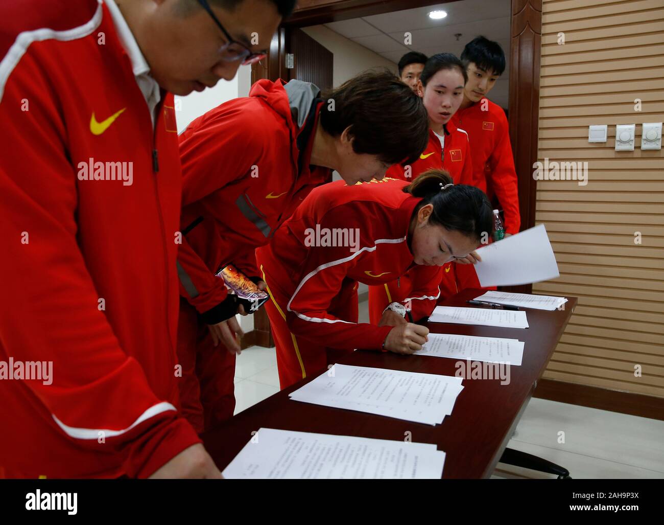 (191227) -- BEIJING, Dec. 27, 2019 (Xinhua) -- File photo taken on April 17, 2019 shows athletes from China's national track and field team sign on Anti-Doping Committment for Asian Athletics Championships 2019 in Beijing, capital of China. On November 18, China's Supreme People's Court issued a judicial interpretation on the handling of criminal cases related to the smuggling, illegal sale and use of athletic performance-enhancing drugs, which will take effect on January 1, 2020. The move will see harsher punishments for those behind illegal doping activities. (Xinhua/Ding Xu)TOP 10 CHINESE S Stock Photo