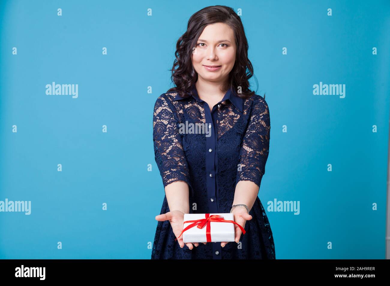 Portrait of a beautiful fashionable Asian woman with a festive gift in a blue stylish dress Stock Photo
