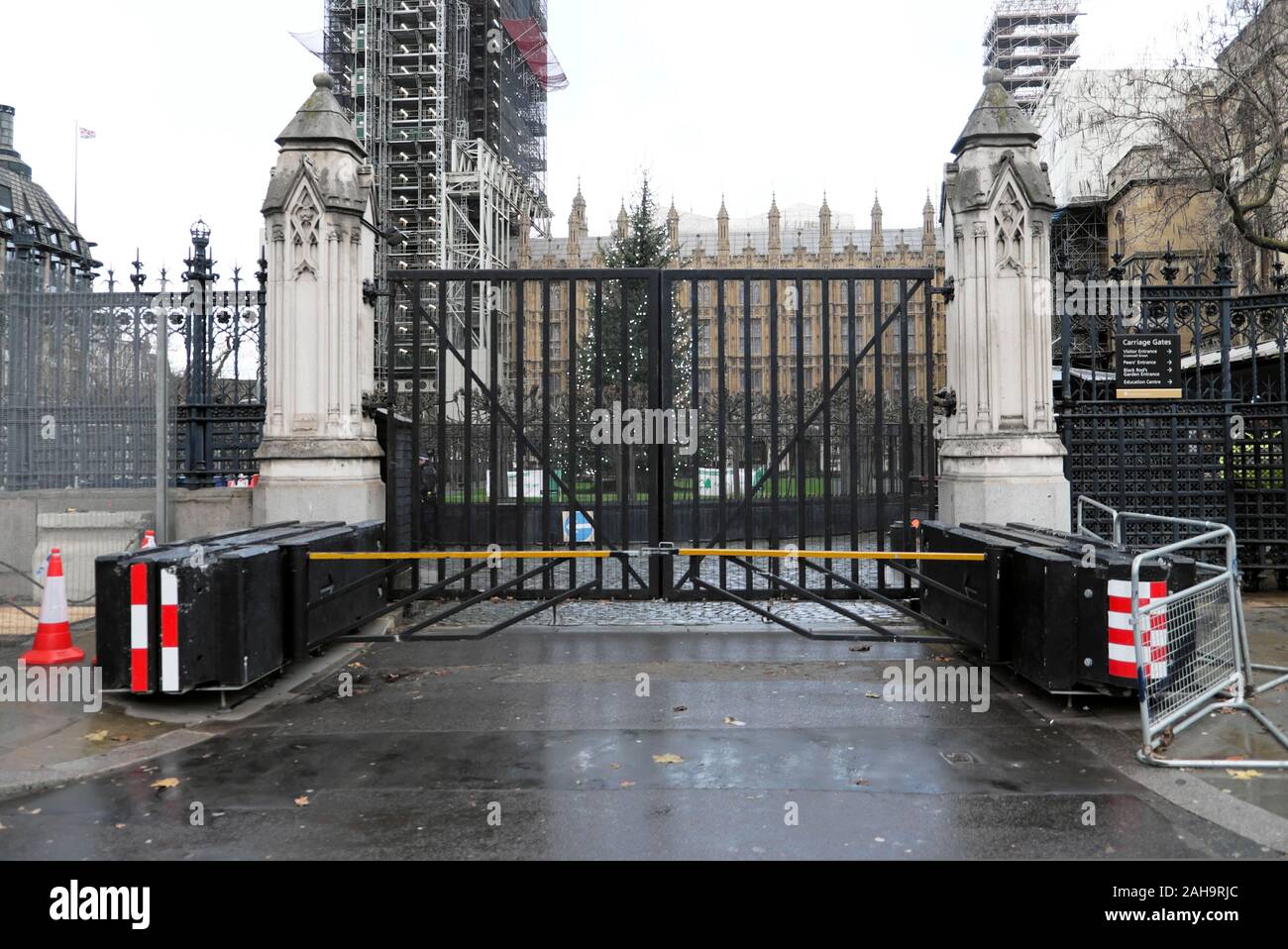 Closed iron gates and anti-terrorist barriers outside the entrance to the Houses of Parliament and Crhistmas tree Westminster London UK  KATHY DEWITT Stock Photo
