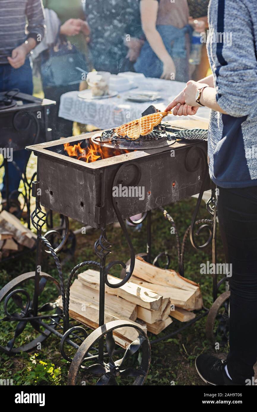 Baking waffles on open flame outdoors in a hammered cast iron grill