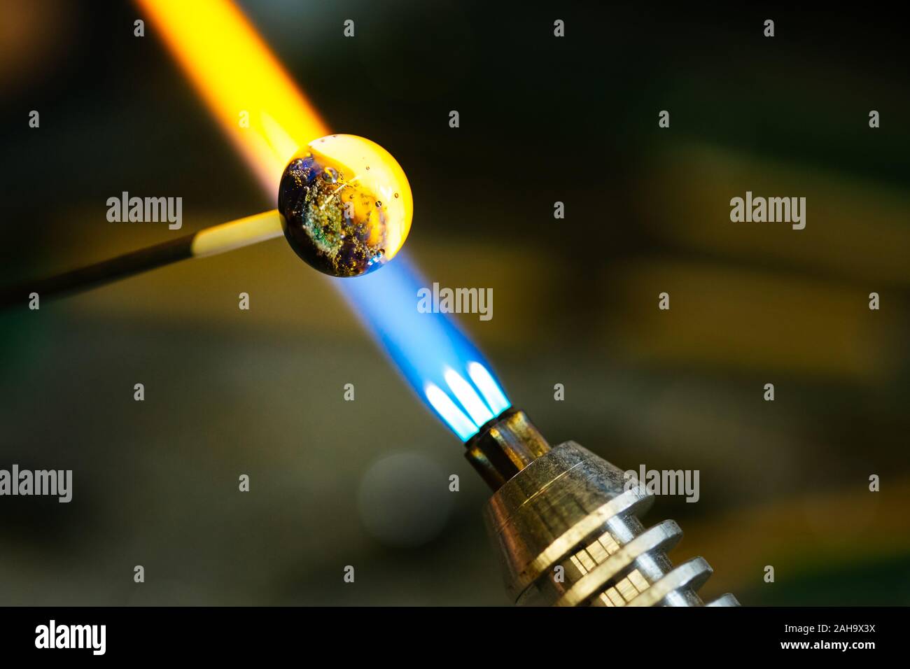 Closeup of glass bead melting in gasburner fire, craftwork Stock