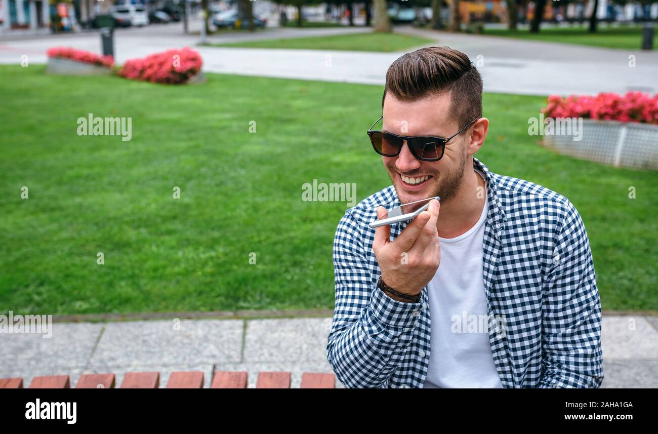 Man sending audio message with mobile Stock Photo