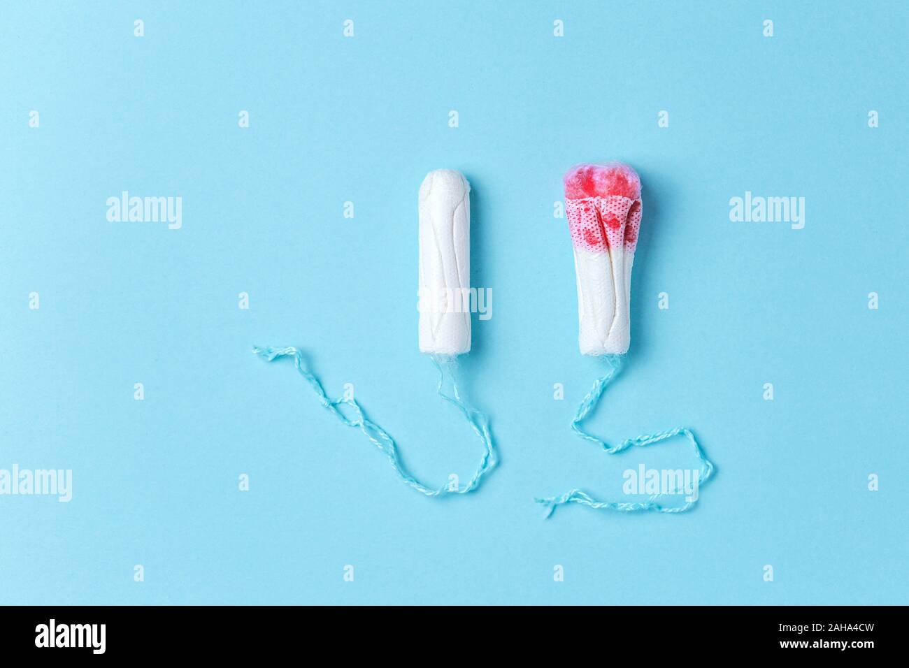 Medical female tampons. Menstruation, means of protection. Used and new  tampon over blue background with place for text Stock Photo - Alamy