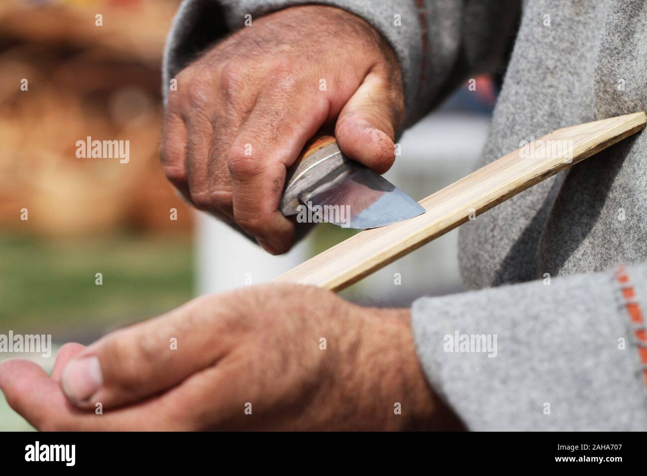 Man sharpened steel knife on whetstone. Stock Photo