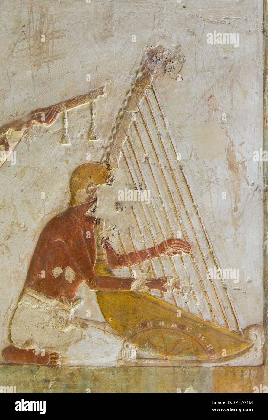 UNESCO World Heritage, Thebes in Egypt, Valley of the Nobles, tomb of Benia. A musician playing harp. The harp is movable thanks to its wheels ! Stock Photo