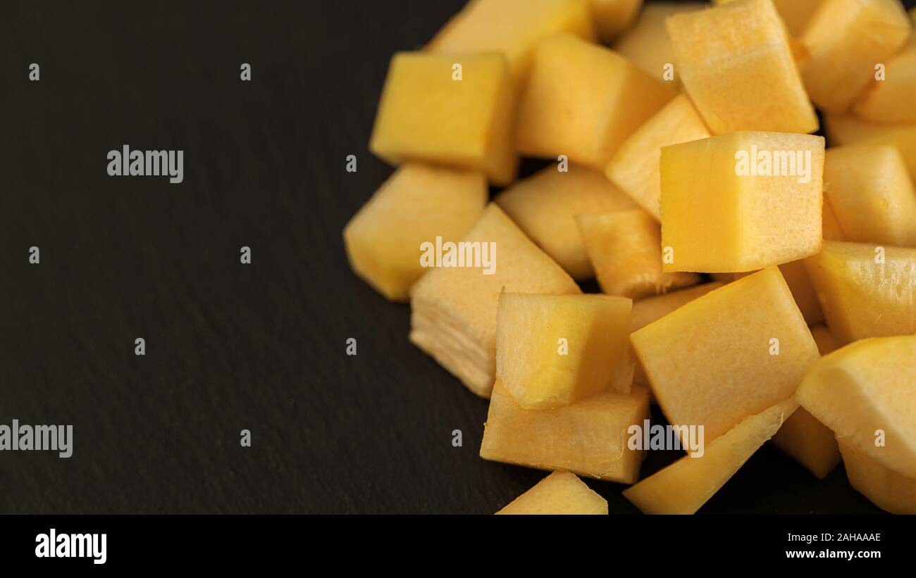 Fresh pineapple cube slices on the black background. Pineapple chunks close up Stock Photo