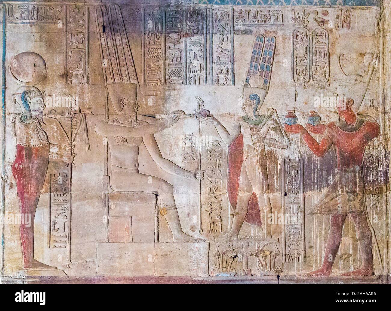 UNESCO World Heritage, Thebes in Egypt, Karnak site, ptolemaic temple of Opet. The king offers Nou vase (wine) to gods Amun-Ra and Khonsu. Stock Photo