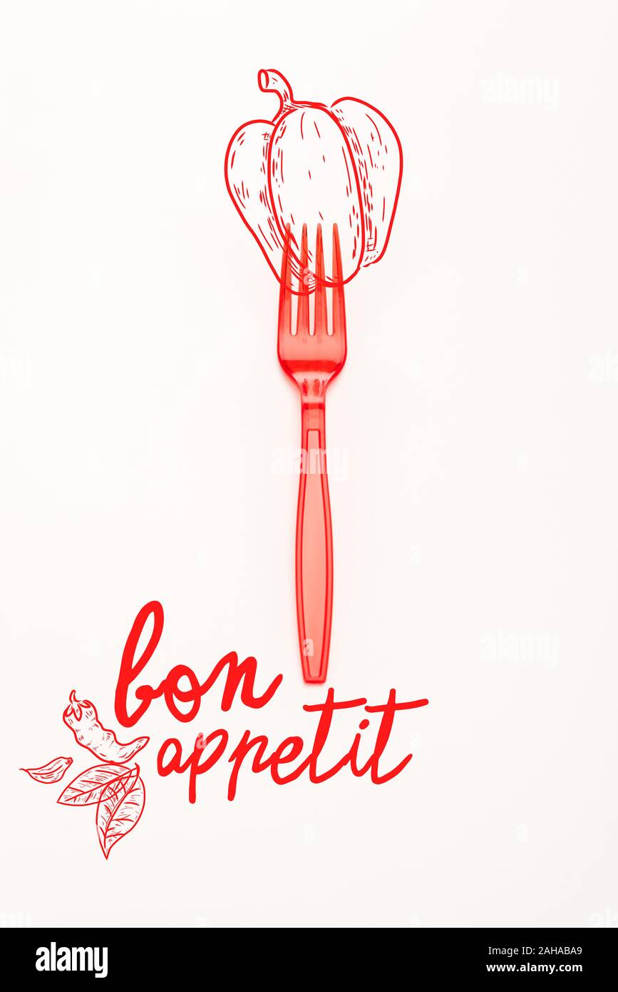 red plastic bright fork with bell pepper illustration and bon appetit lettering isolated on white Stock Photo