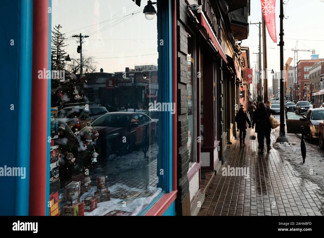 Winter toy shop store front window and snowy pavement, looking south