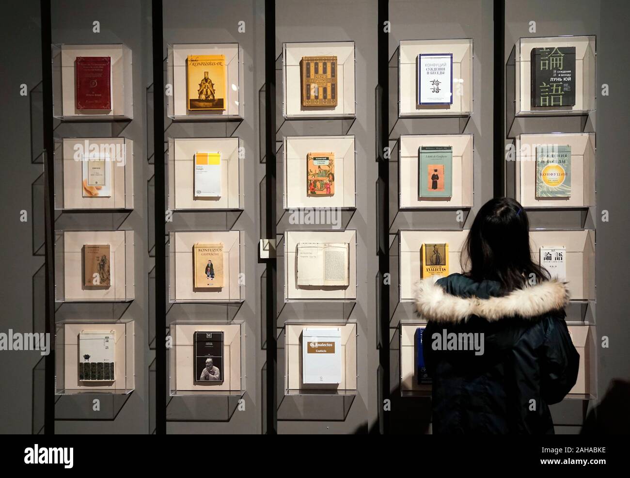 Beijing, China. 27th Dec, 2019. A visitor looks at The Analects of Confucius of different language versions at the National Museum of China in Beijing, capital of China, Dec. 27, 2019. A Confucius culture exhibition was held here on Friday showcasing the formation, development and inheritance of Confucianism. Credit: Jin Liangkuai/Xinhua/Alamy Live News Stock Photo
