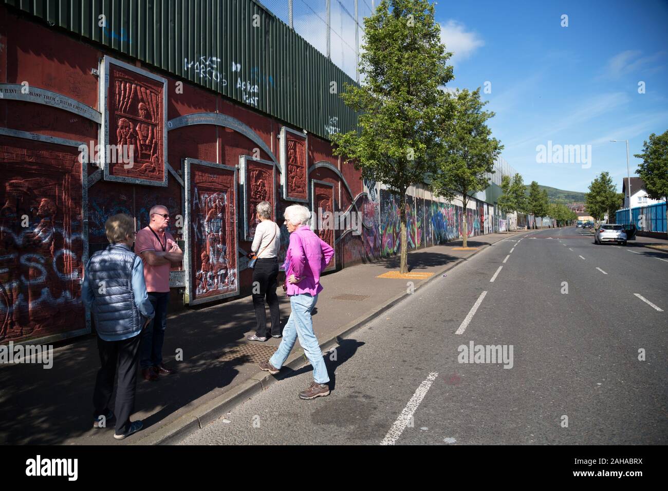 14.07.2019, Belfast, Northern Ireland, Great Britain - Protestant part of West Belfast (Cupar Way), guide with tourists at the Peace Wall, which divid Stock Photo