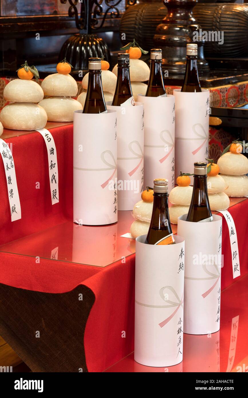 bottles of sake rice liquor placed as offerings in front of kagami