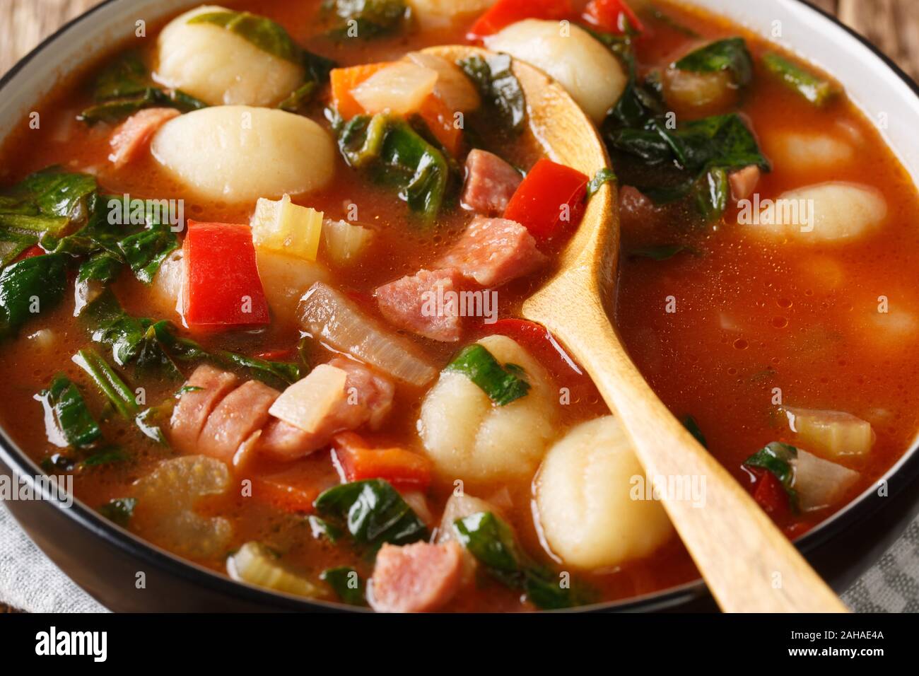 Tuscan tomato soup with gnocchi, Italian sausages and vegetables close-up in a bowl on the table. horizontal Stock Photo