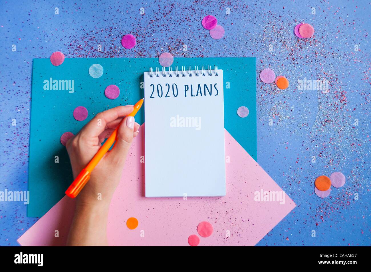 Colorful confetti, sparkles and notebook with wish list on bright