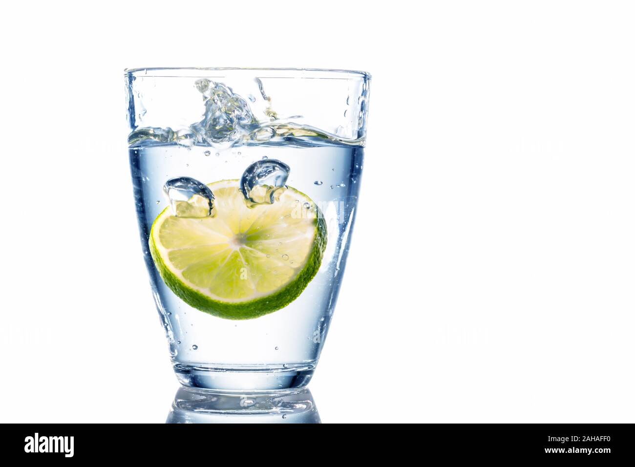Ein  Glas mit Wasser und Limette vor weissem Hintergrund, Symbolfoto für Trinkwasser, Wasserbedarf und Verbrauch, Glas, Stock Photo