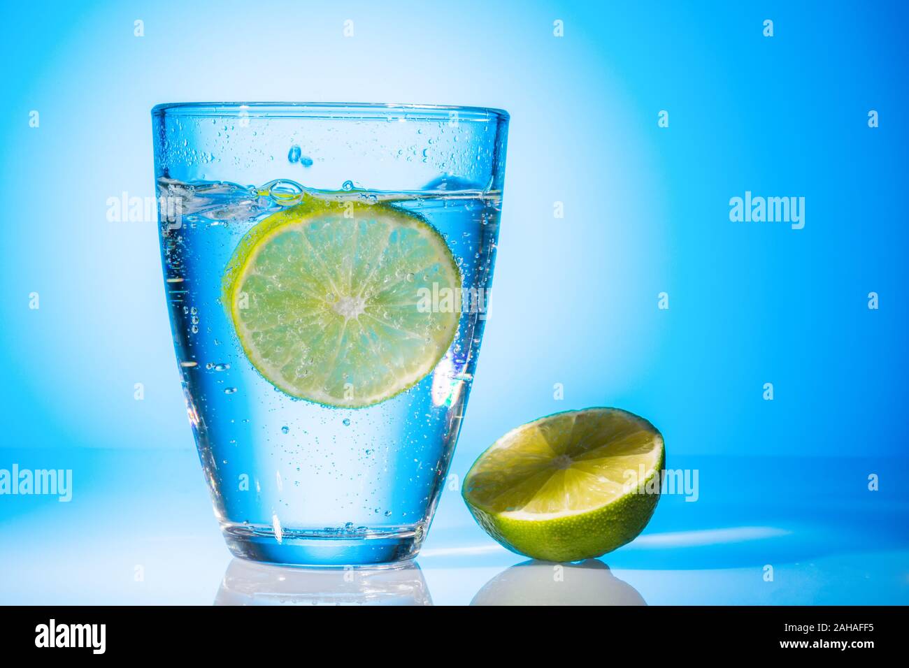 Ein  Glas mit Wasser und Limette vor weissem Hintergrund, Symbolfoto für Trinkwasser, Wasserbedarf und Verbrauch, Glas, Stock Photo
