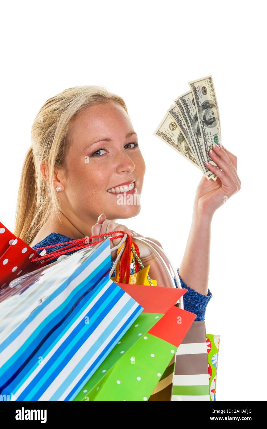 Eine junge Frau kommt mit vielen Einkaufstaschen vom Shopping zurück. Mit amerikanischen US-Dollars in der Hand. MR: Yes Stock Photo
