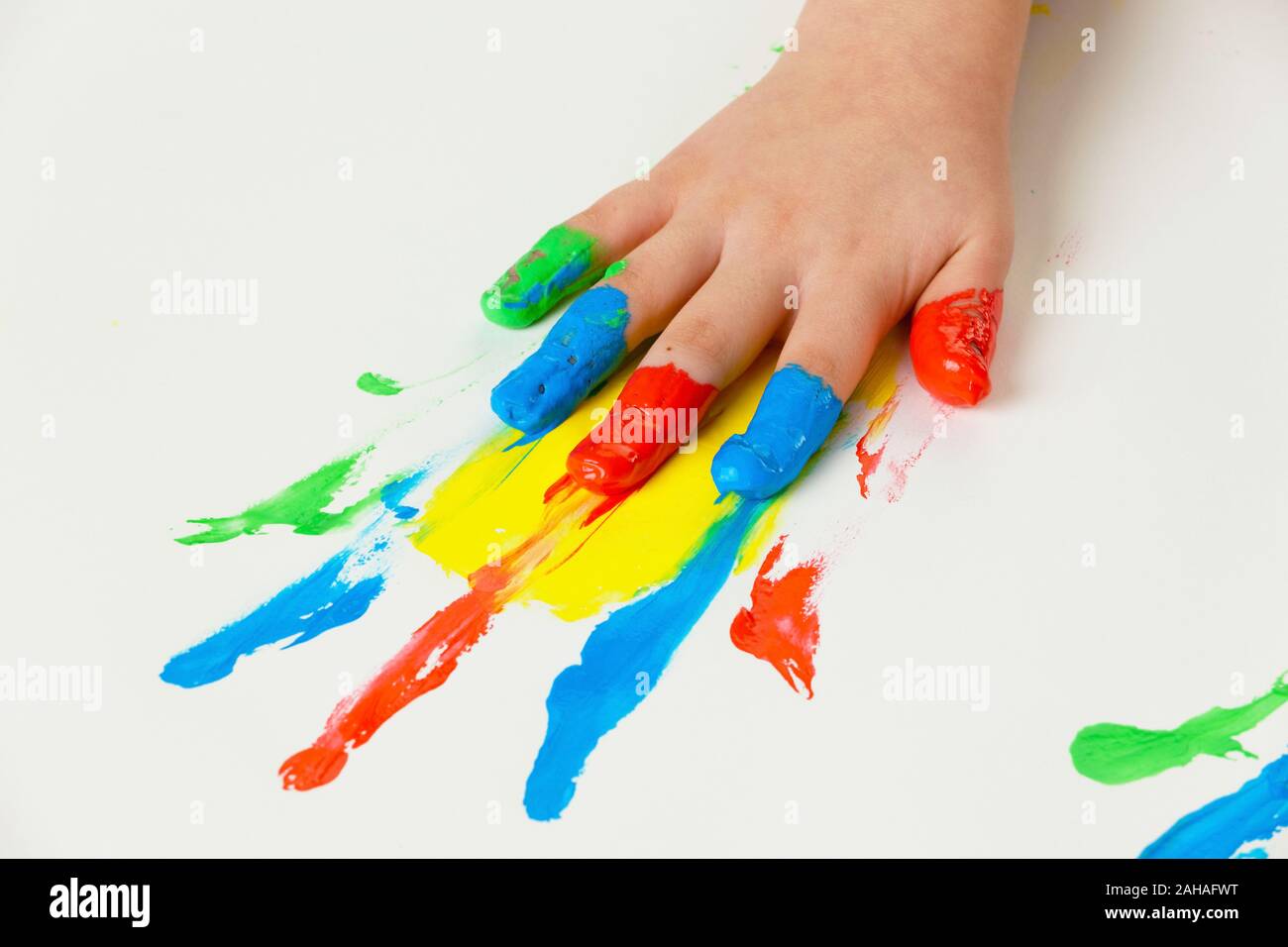 Ein kleines Kind malt mit Fingerfarben. Lustig und Kreativ, bunt, gelb, rot, blau, Stock Photo