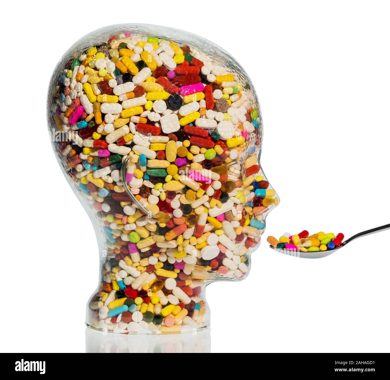 Glaskopf mit bunten Tabletten, Symbolfoto für Medizin, Heilmittel und Tablettensucht Stock Photo