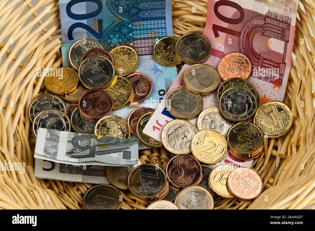 Ein Korb mit Euro-Banknoten und Münzen, Bettler, Obdachloser, Sammeln, Stock Photo