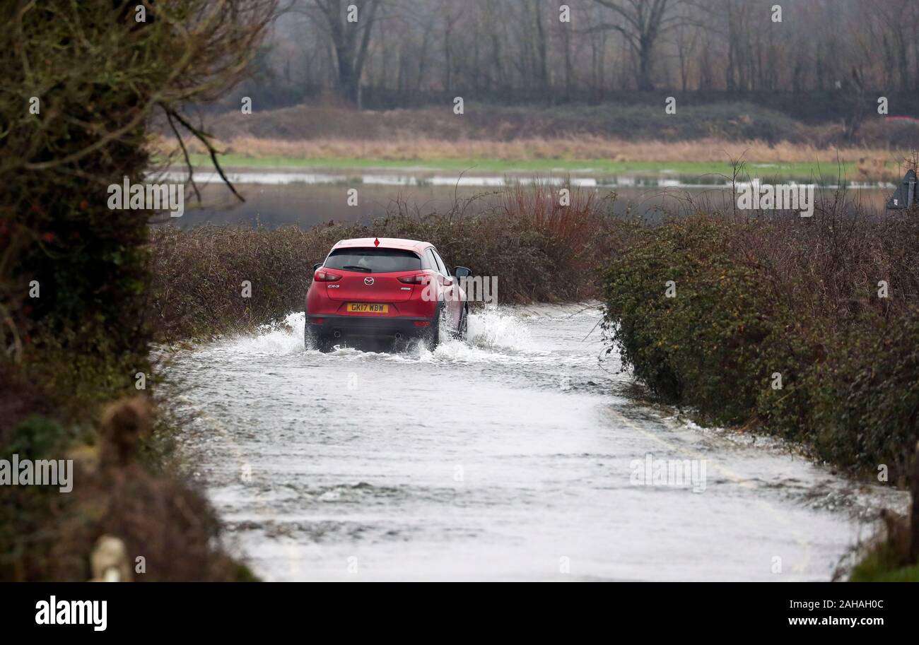 A car tries to srive down a flooded road near Harbridge, 2.5 miles north of Ringwood in Hampshire, after the river Avon burst its banks. Stock Photo