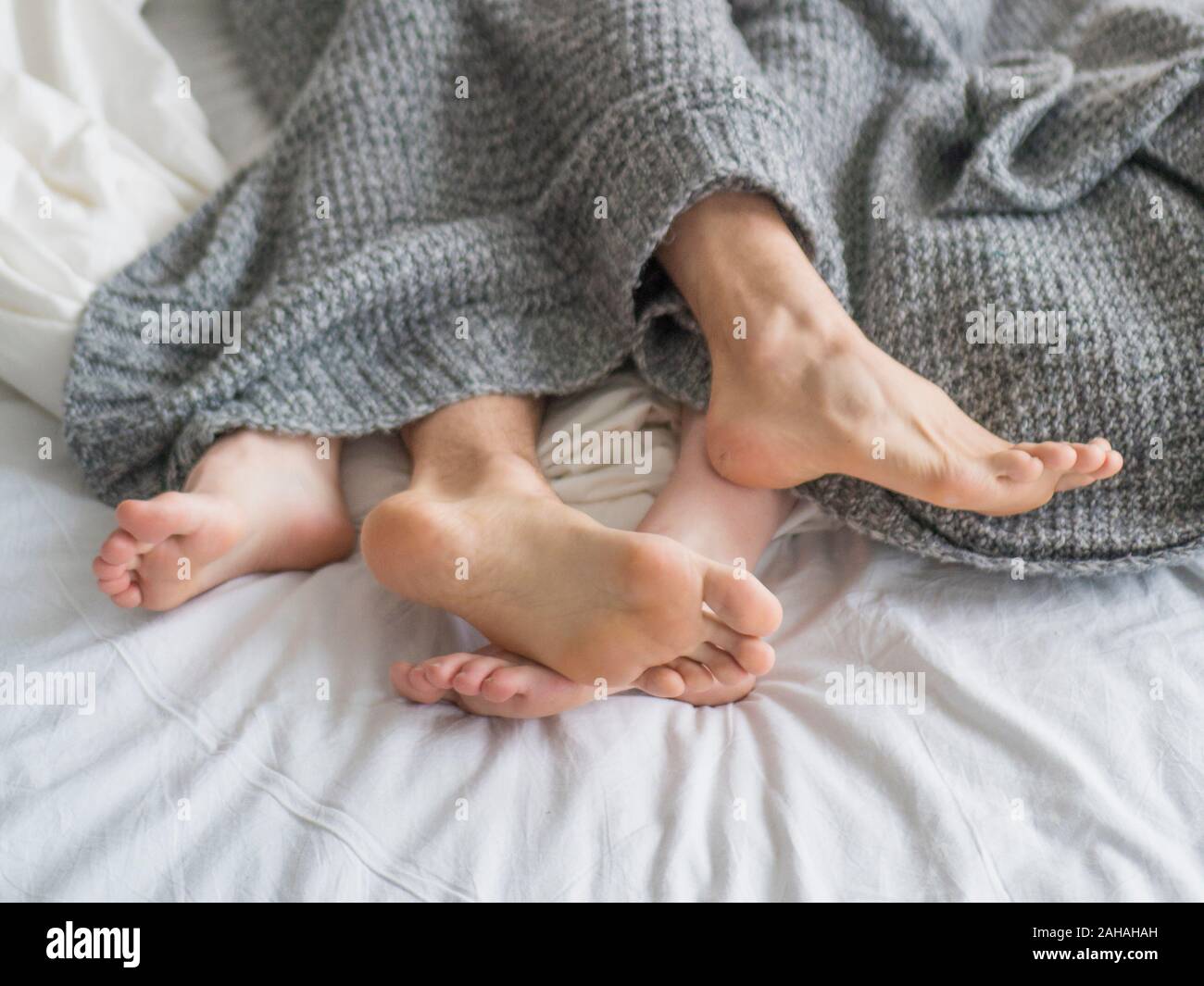 Couple sleeping in bed. Close up view of a feet of a couple. Love and relationships concept. Stock Photo