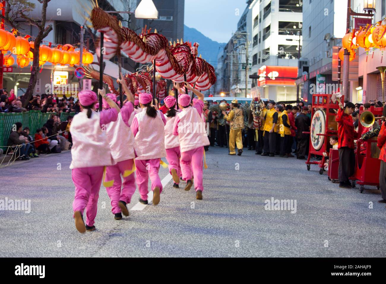 This is a picture of a group performing a dragon dance in the street during lantern festival in Nagasaki Japan. Stock Photo