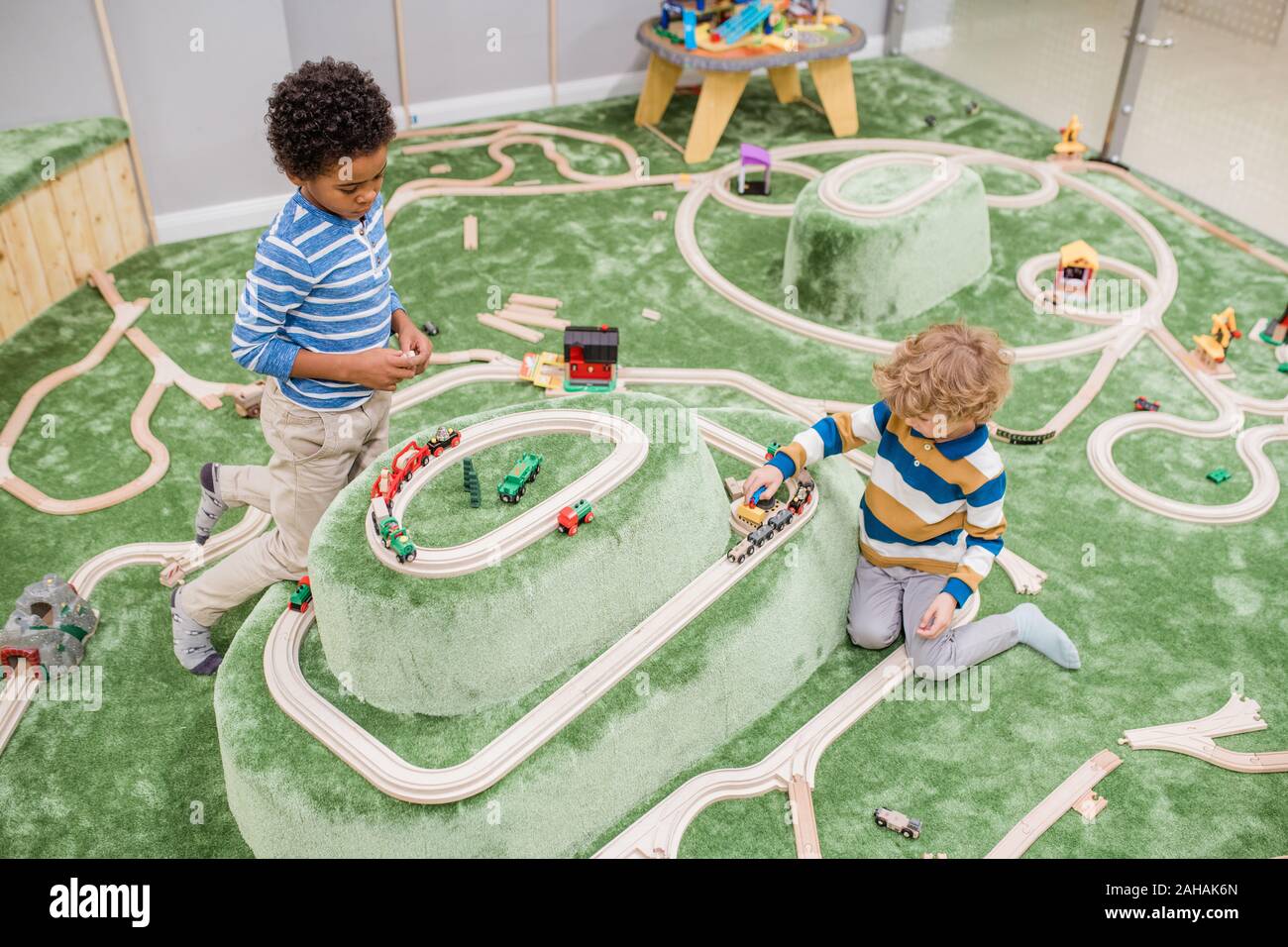 Two intercultural little boys spending time on play area of children center Stock Photo
