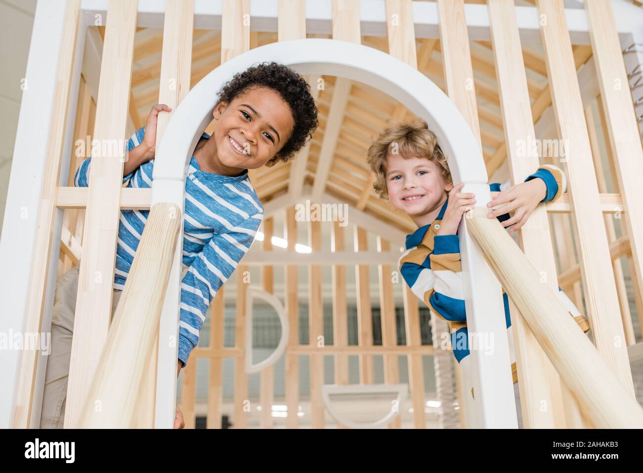 Cute cheerful preschoolers having fun on playground at children center Stock Photo