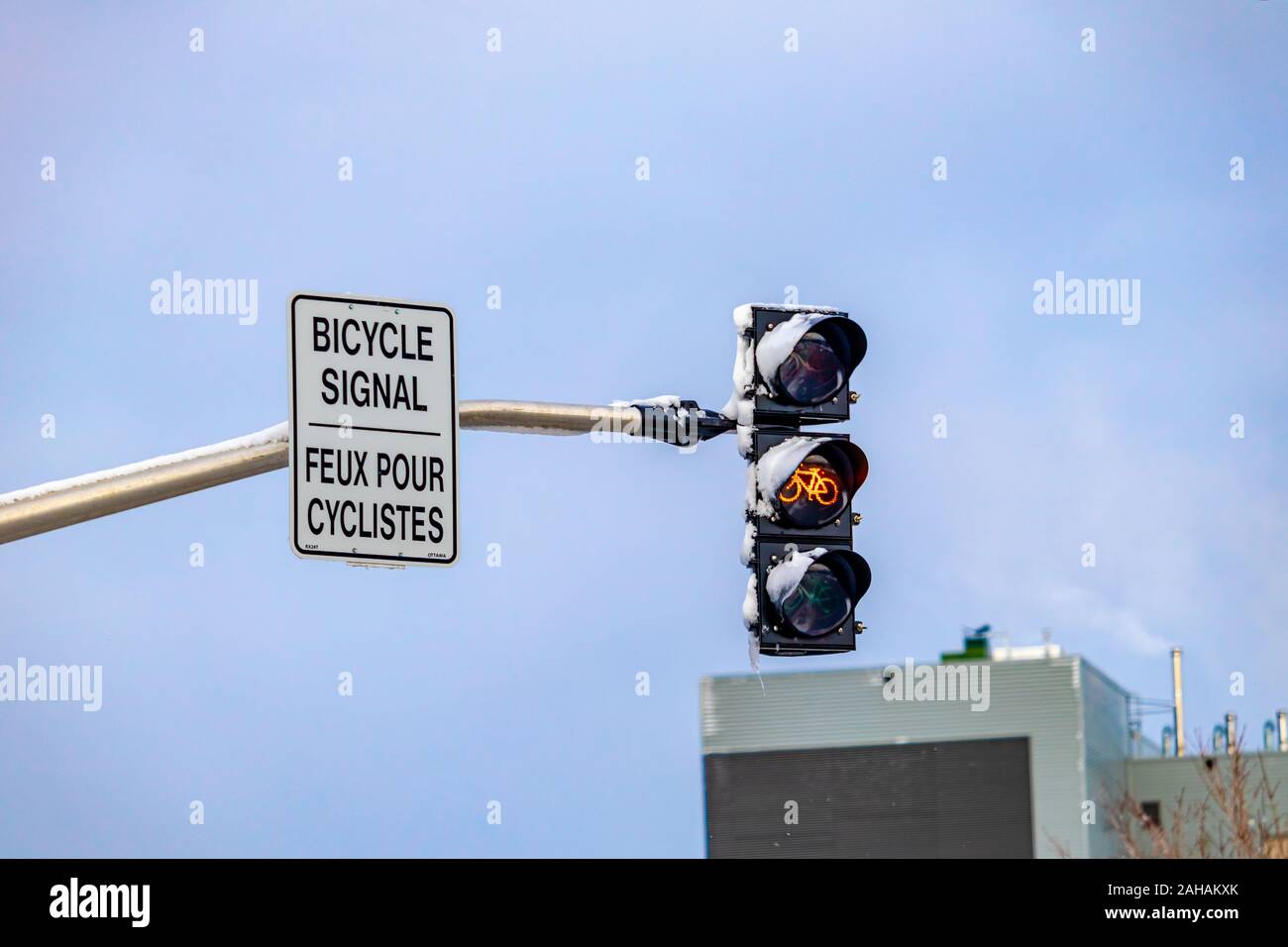 A traffic signal for a bike lane turns yellow, warning cyclists to slow