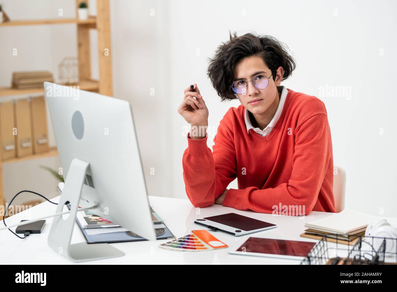 Creative designer looking at you while concentrating on work over new website Stock Photo
