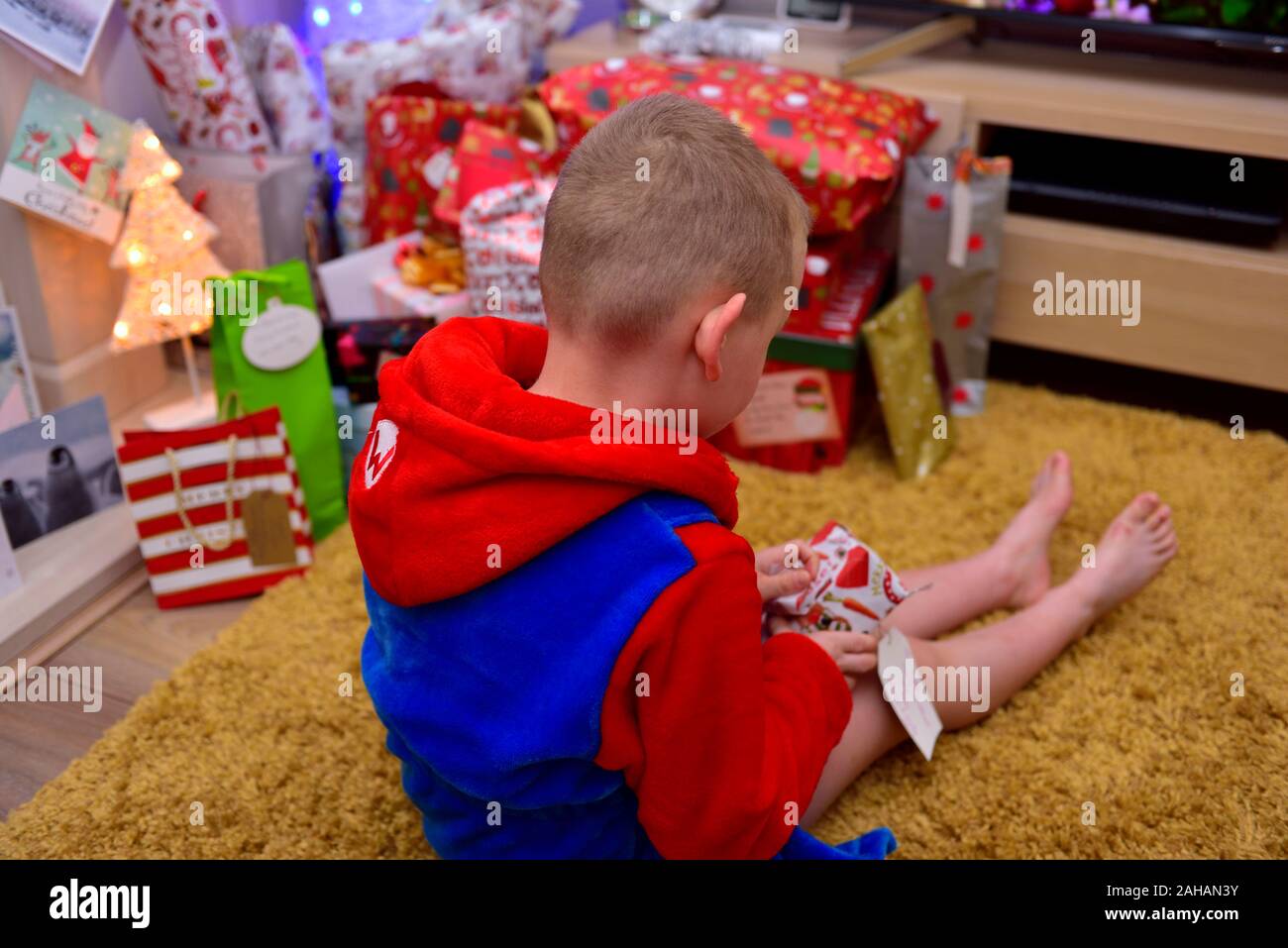 7 year old boy opening a christmas present Stock Photo