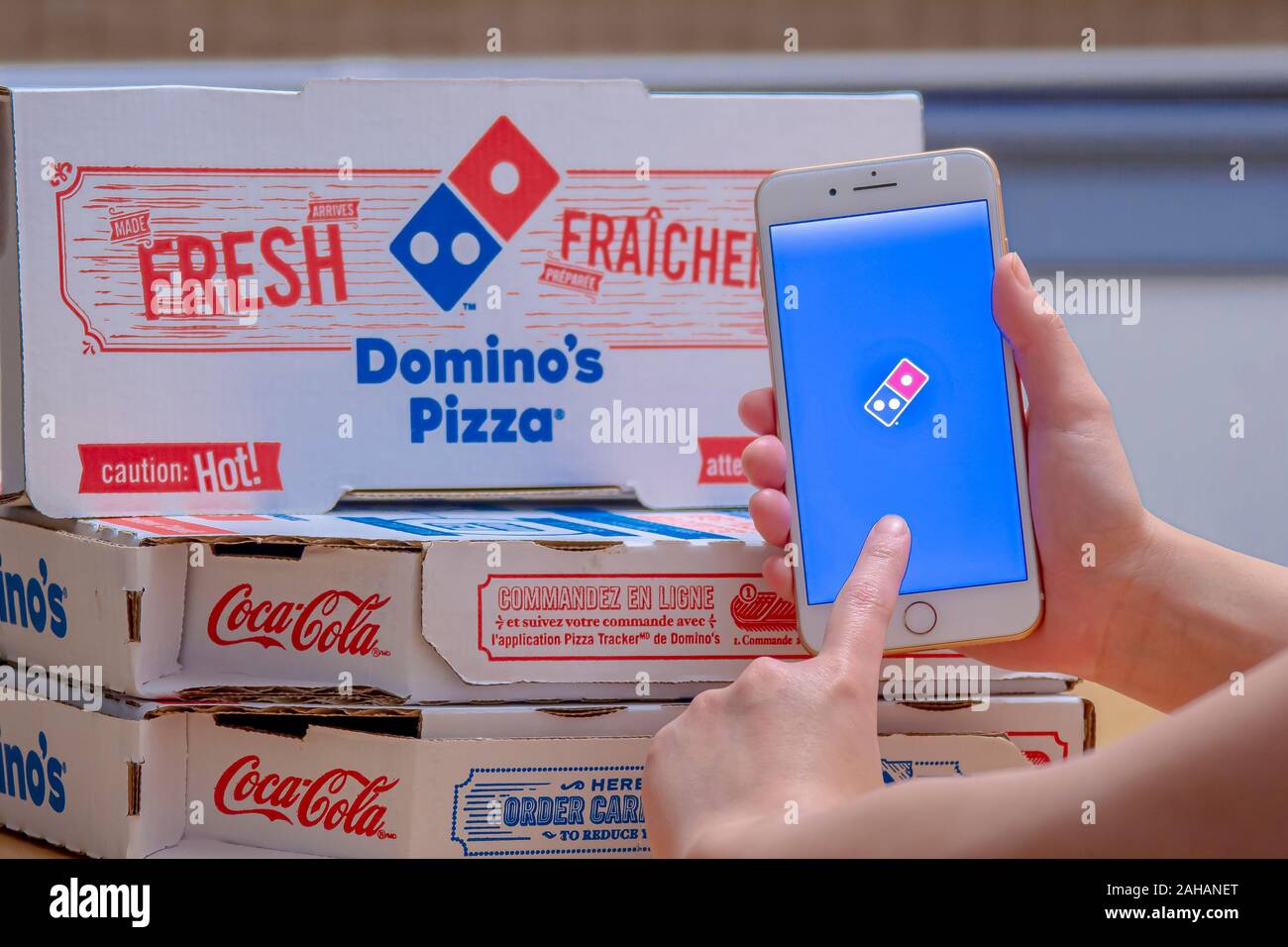 Close up of a person using the Domino’s Pizza application on an iPhone Plus. Domino’s Pizza Stock Photo
