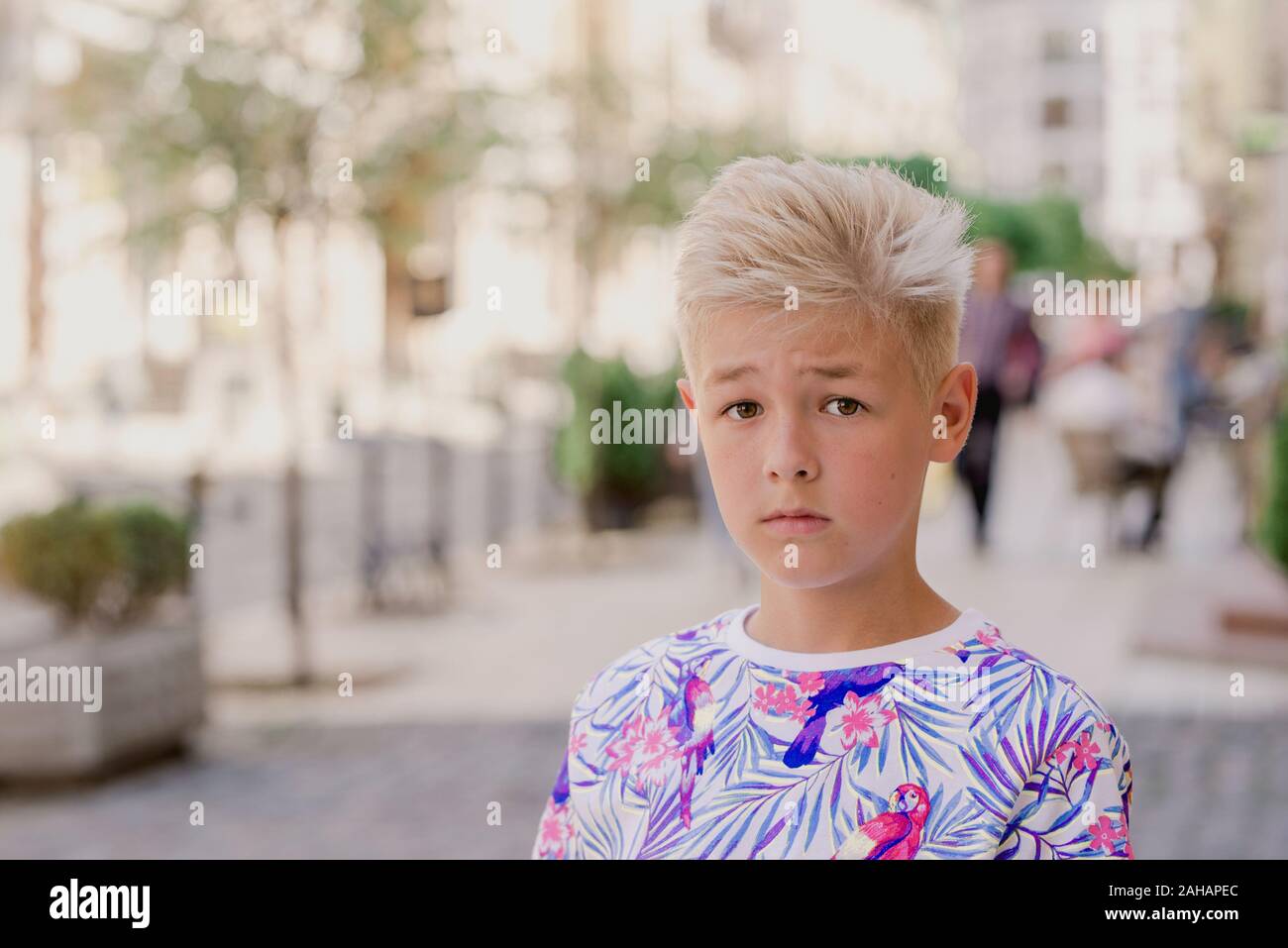 portrait of cute handsome blonde eleven old boy (teenager) lost in the city. Growing up, chilhood, separating concept Stock Photo