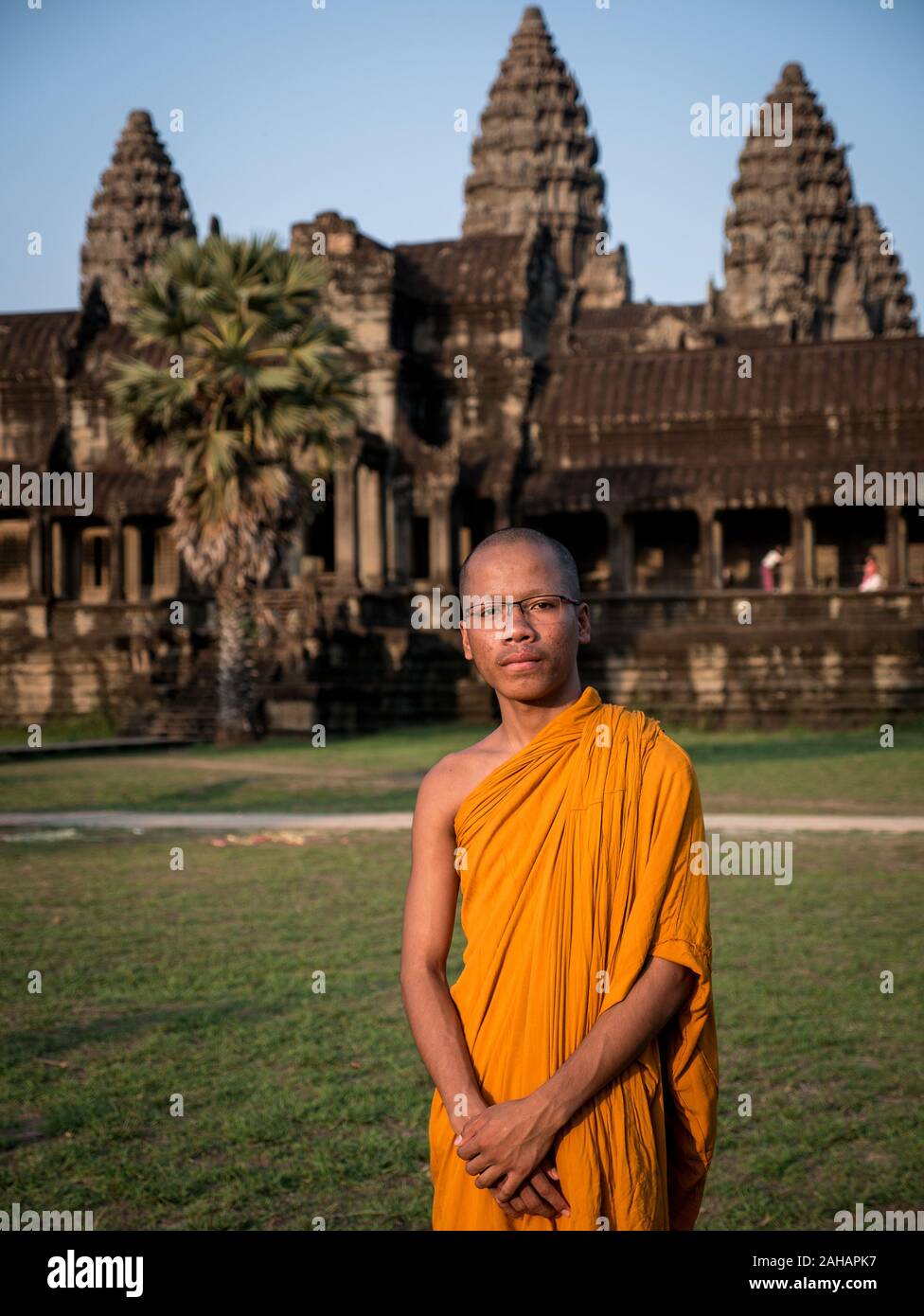 Buddhist monk in traditional orange ceremonial robe at Angkor Wat temple Stock Photo