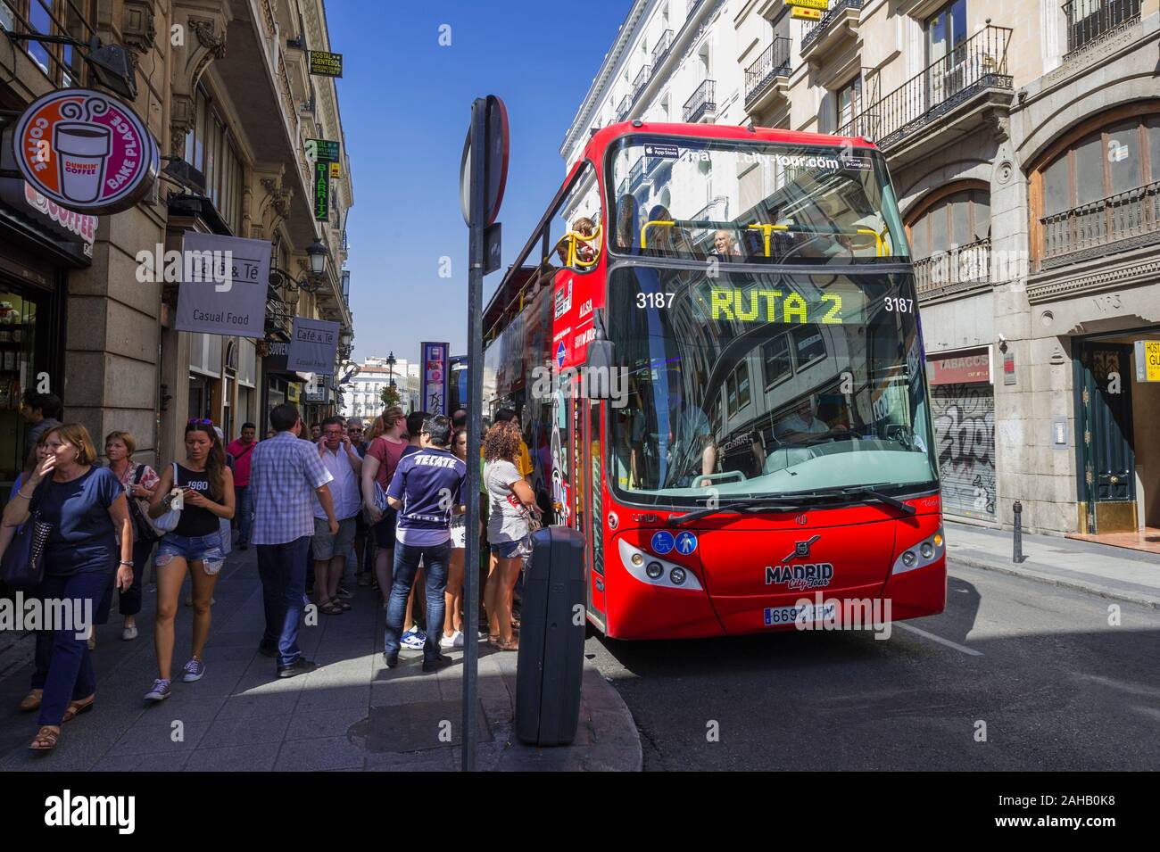 People getting on a Tour Bus at a Bus Stop in Madrid, Spain Stock Photo