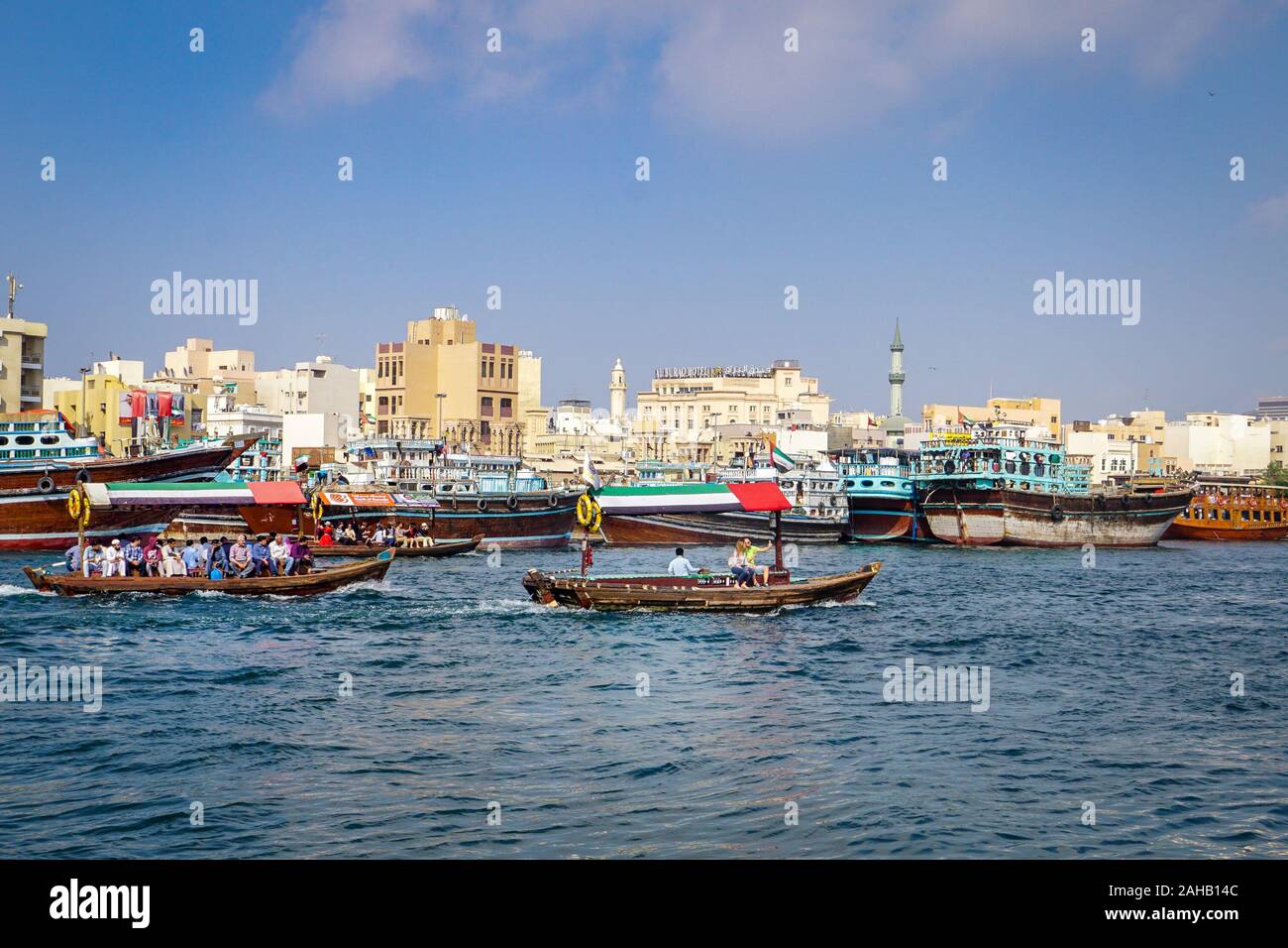 Abra water taxis cross Dubai Creek in front of the old district of Deira, in Dubai, in the United Arab Emirates Stock Photo