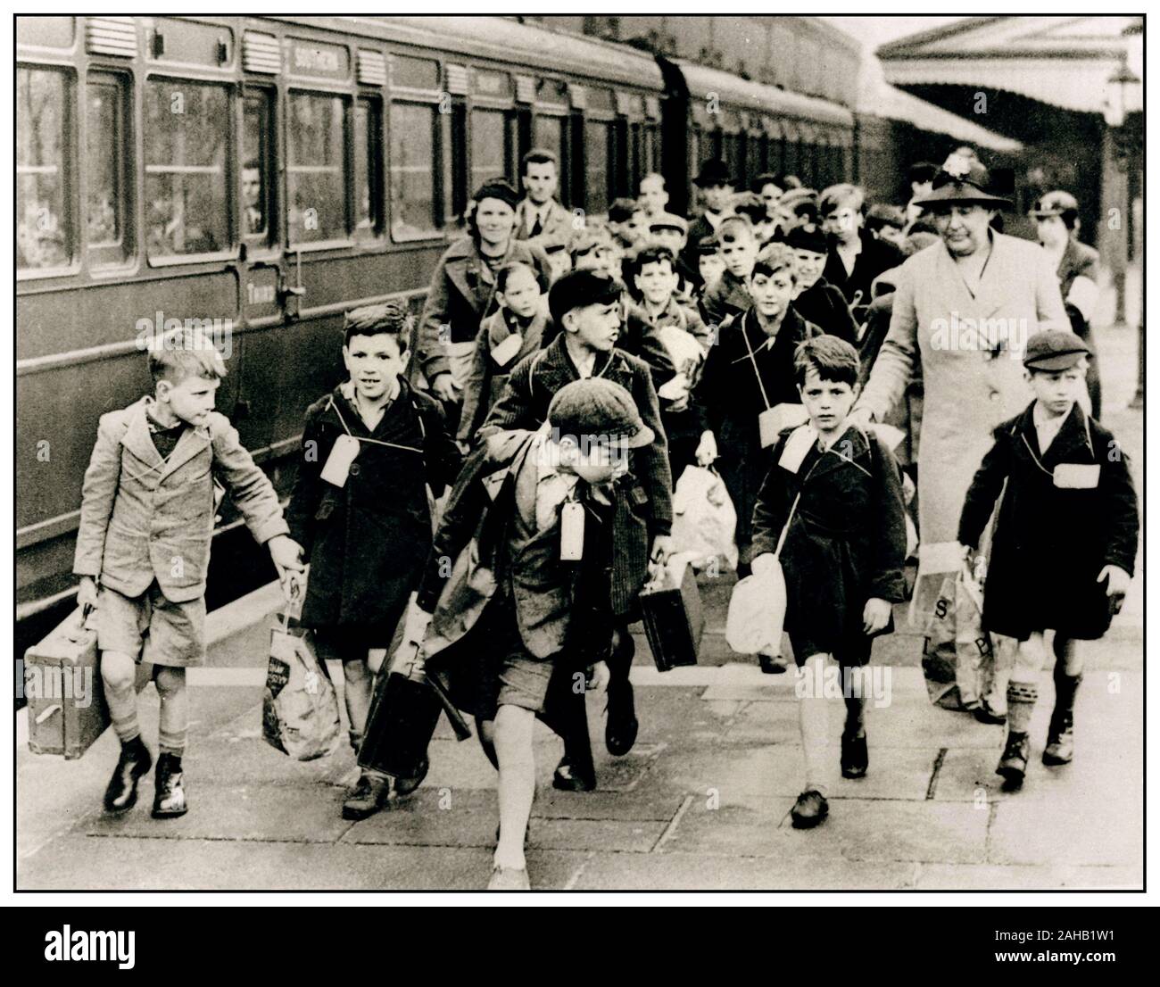 Blitz World War II WW2 Children evacuees with suitcases wearing name tag labels at Moor Street Railway Station, Birmingham, leaving for rural countryside accommodation to avoid Nazi Germany blitz bombing of British cities September, 1939. Children of the wartime evacuation, millions of British city children were evacuated to safer places during the Second World War. WW2 Stock Photo