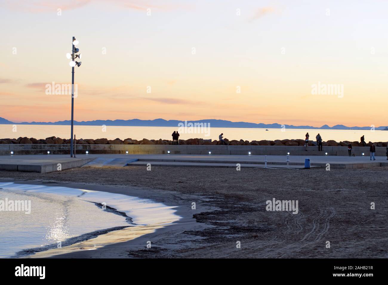 Torrevieja, Spain, December 26, 2019: Beach of Torrevieja during sunrise. People walking outdoors enjoy the view Stock Photo