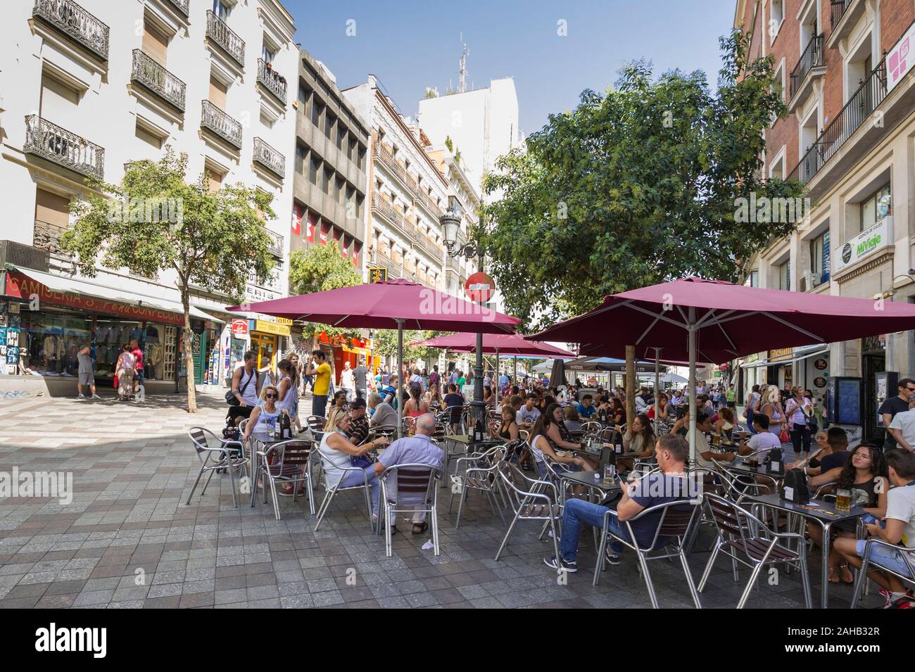 People sitting underneath large umbrellas in a pavement cafe in Madrid, Spain Stock Photo