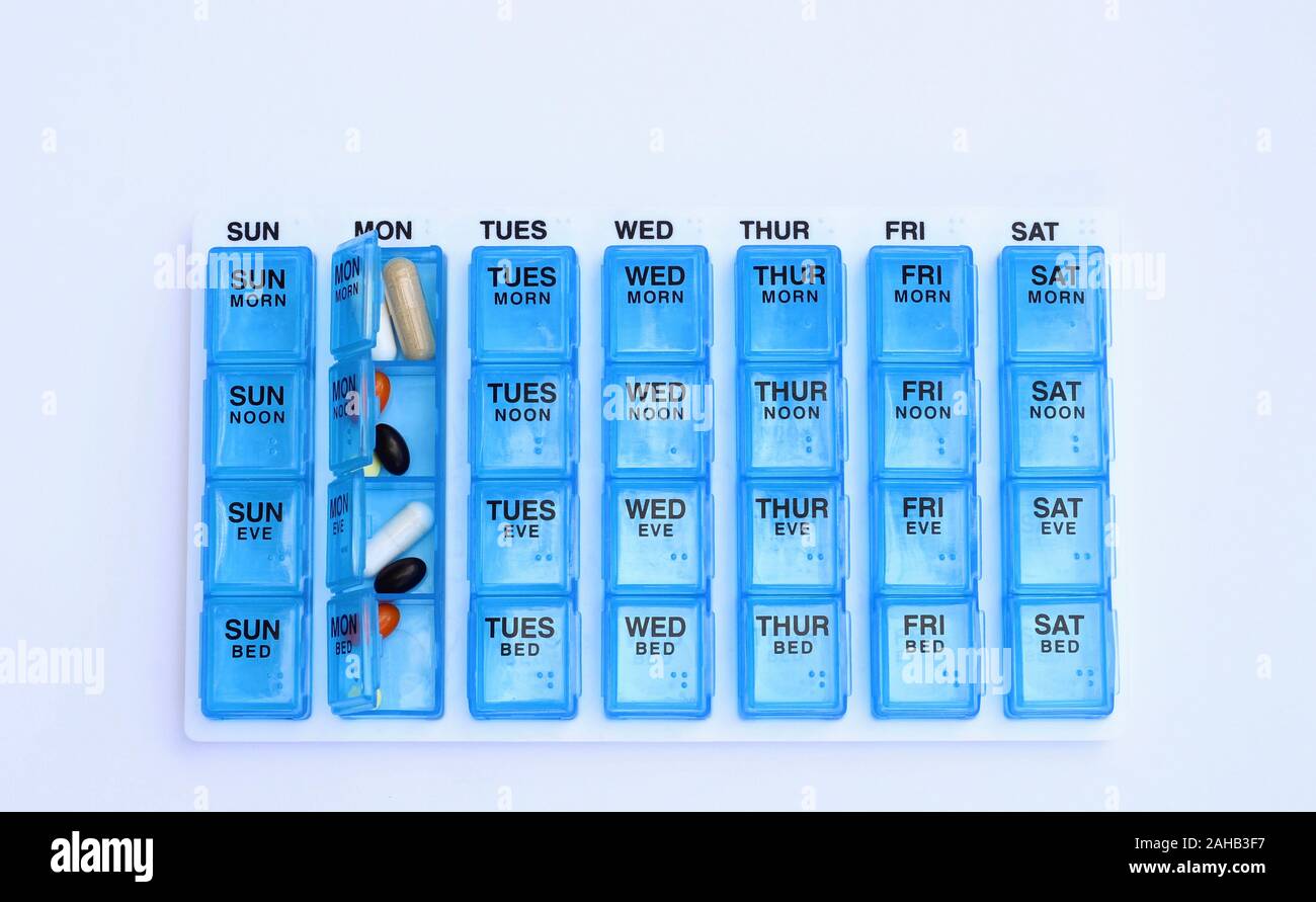 monthly pill organizer with separate compartments for 30 days with pills inside top view on a white background with copy space Stock Photo