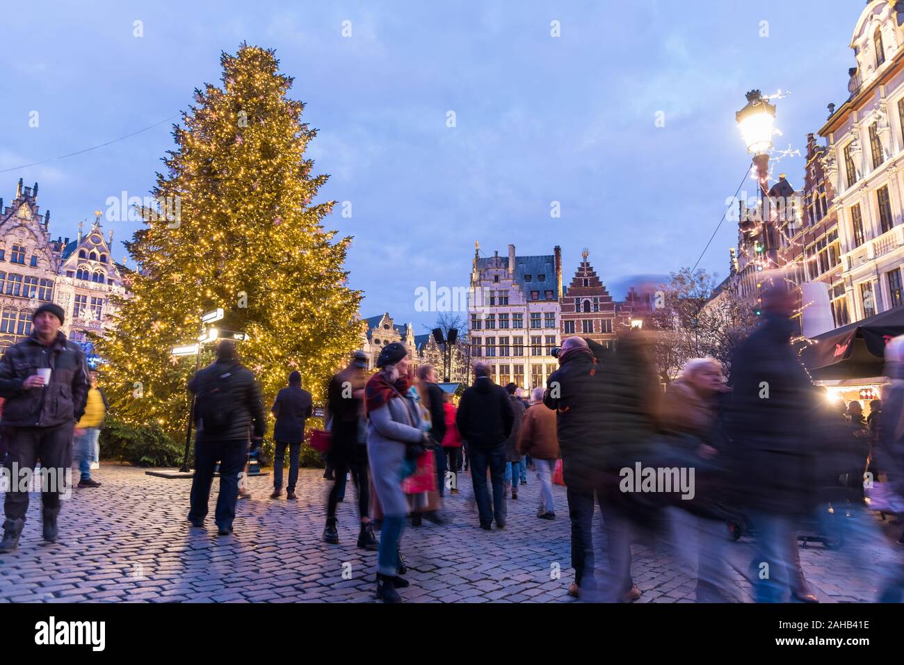 People wandering around the Christmas market in Grote Markt square in Antwerp, Belgium, at dusk Stock Photo